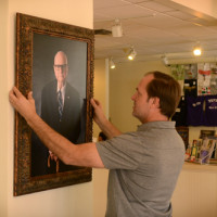 Greg Patterson holding a portrait of Charles Bright in the building that now bears his name.