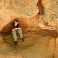 Nathan Patterson sits in the shelter of a rock.